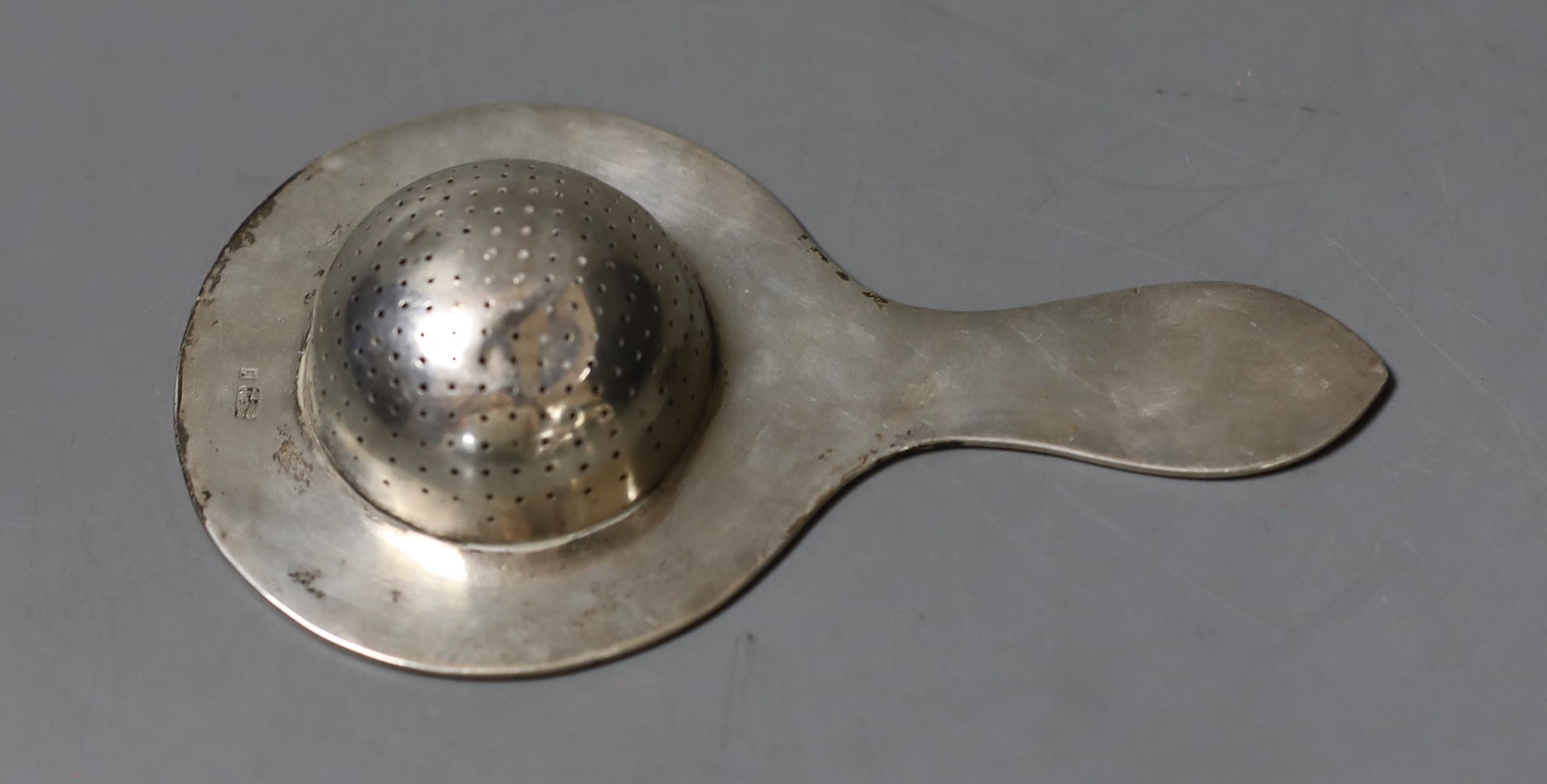 A Chinese Export white metal tea strainer, maker TC, 14.2cm, 47 grams.